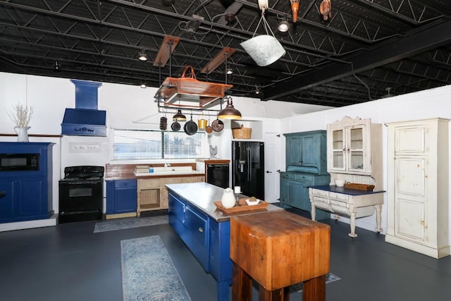 kitchen featuring black appliances, blue cabinetry, and premium range hood