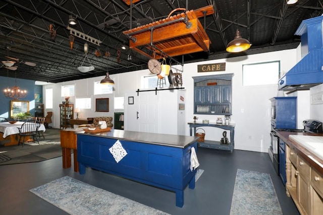 kitchen featuring custom exhaust hood, pendant lighting, and a notable chandelier