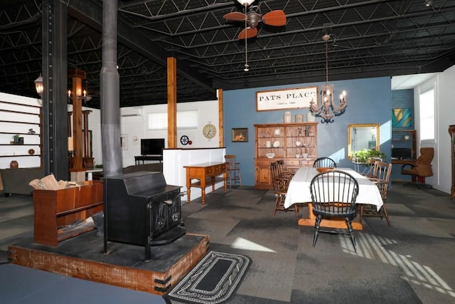 dining room with ceiling fan and a wood stove