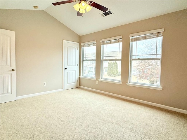 carpeted spare room with ceiling fan, lofted ceiling, and a wealth of natural light