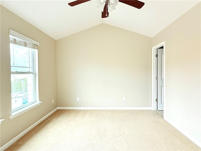 carpeted spare room with ceiling fan and vaulted ceiling