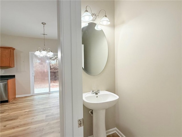 bathroom featuring wood-type flooring, a notable chandelier, and sink