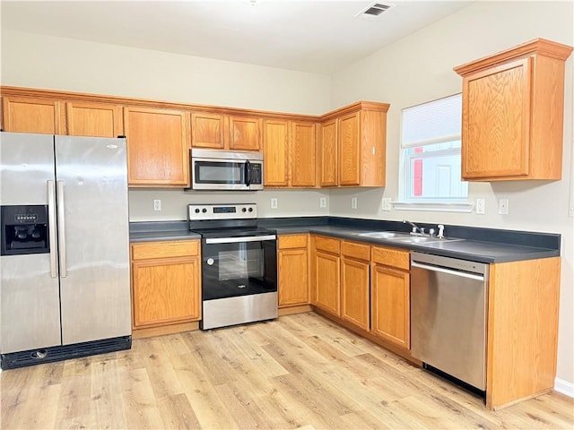 kitchen with light wood-type flooring, sink, and appliances with stainless steel finishes