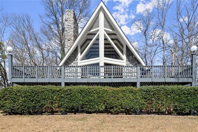 rear view of house featuring a chimney and a wooden deck