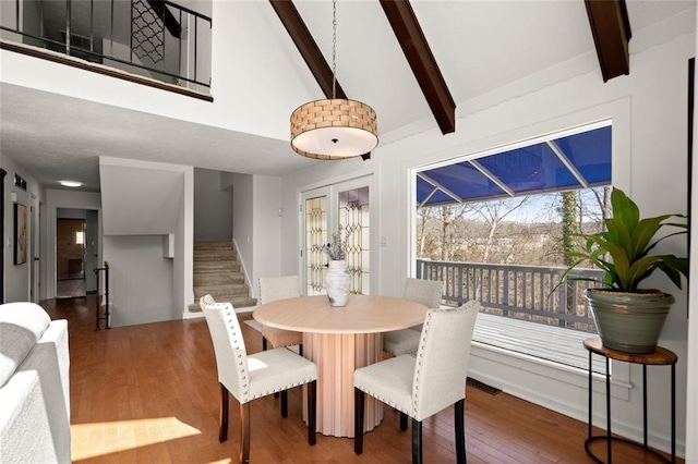 dining room featuring high vaulted ceiling, beam ceiling, stairway, and hardwood / wood-style flooring