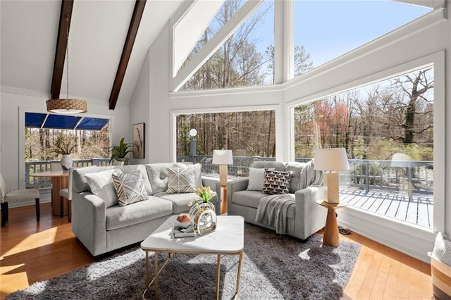 living area with high vaulted ceiling, wood finished floors, beam ceiling, and a healthy amount of sunlight