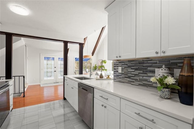 kitchen featuring appliances with stainless steel finishes, light countertops, french doors, white cabinetry, and a sink