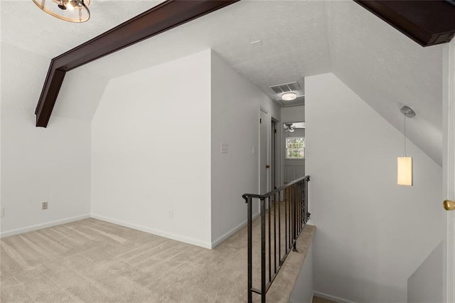 additional living space with carpet floors, visible vents, vaulted ceiling, and baseboards