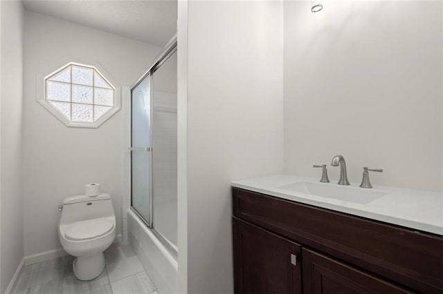 full bathroom with baseboards, shower / bath combination with glass door, vanity, and toilet