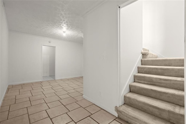 unfurnished room featuring stairs, ornamental molding, a textured ceiling, and baseboards