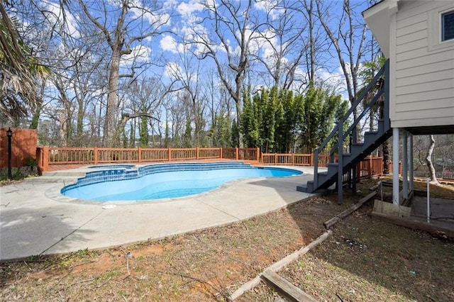 view of swimming pool featuring a fenced backyard, stairs, a pool with connected hot tub, and a patio