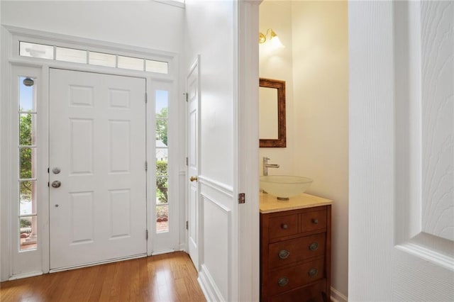 entryway with sink and light hardwood / wood-style floors