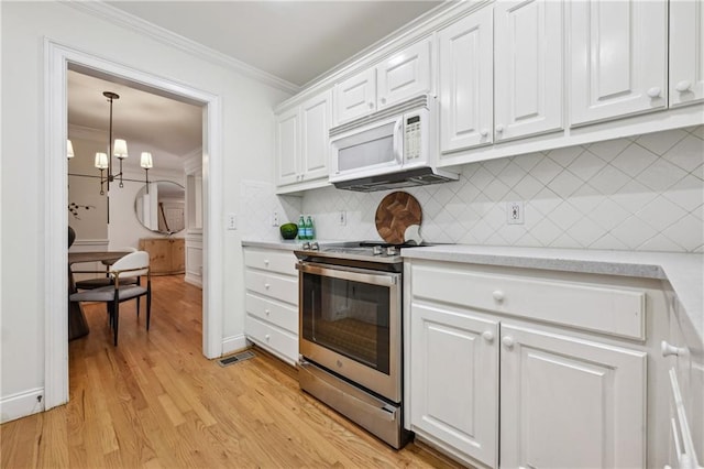 1634 Ponce De Leon Ave NE Unit 514, Atlanta, GA 30307 - kitchen with electric stove, white microwave, light countertops, ornamental molding, and white cabinets