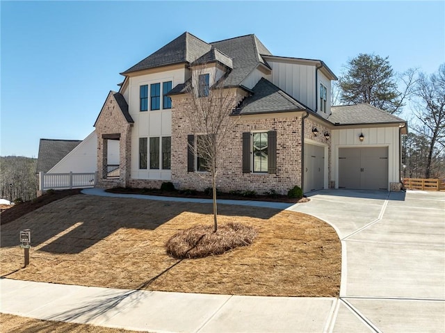 view of front of home featuring an attached garage, brick siding, driveway, roof with shingles, and board and batten siding