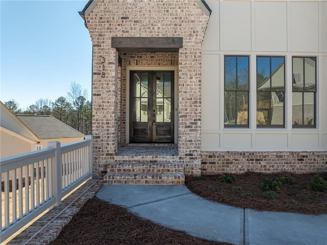 doorway to property featuring french doors and brick siding