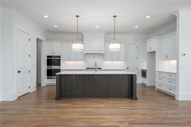 kitchen with light countertops, stainless steel double oven, custom exhaust hood, and white cabinetry