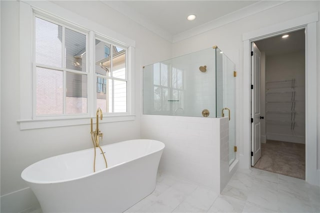 bathroom featuring a walk in closet, marble finish floor, recessed lighting, a soaking tub, and a shower stall