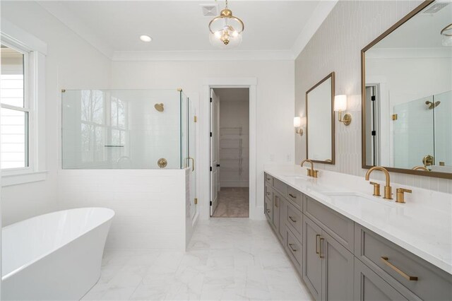 bathroom with a stall shower, crown molding, and a sink