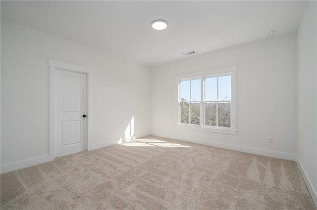 spare room with carpet floors, baseboards, and visible vents