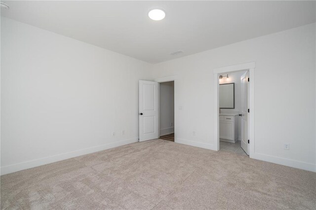 unfurnished bedroom with baseboards and light colored carpet