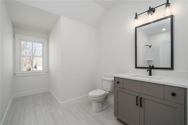 full bathroom featuring toilet, baseboards, a shower, and vanity