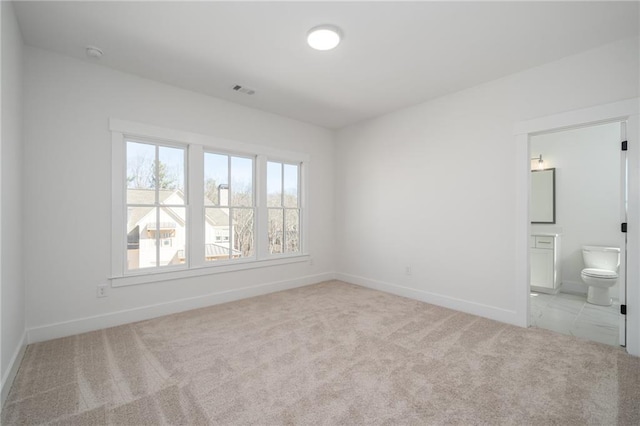 interior space with visible vents, carpet flooring, ensuite bath, and baseboards