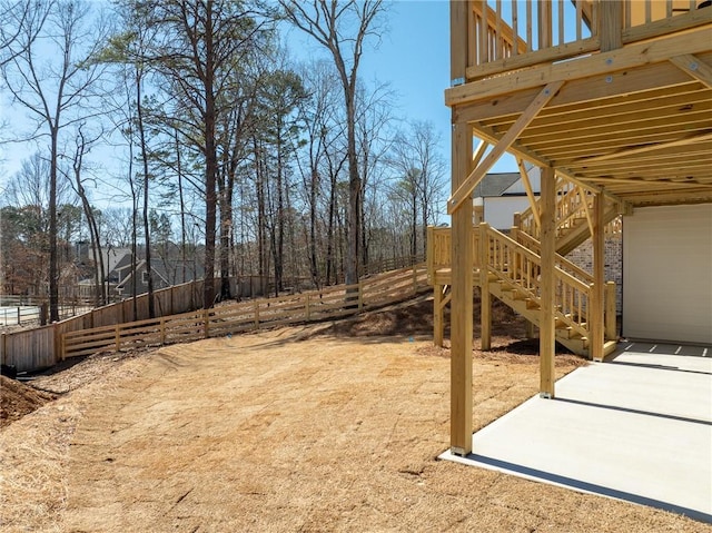 view of yard with a patio area, stairs, and fence