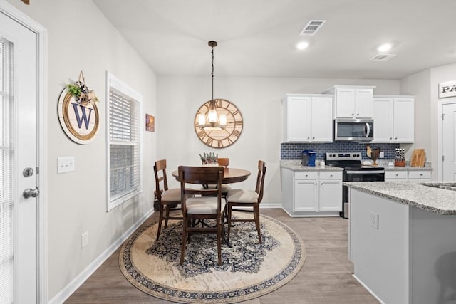 2046 Westbrook Rd, Commerce, GA 30530 - kitchen with appliances with stainless steel finishes, light wood-type flooring, tasteful backsplash, white cabinetry, and recessed lighting