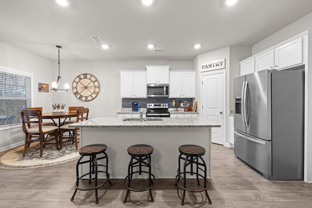 2046 Westbrook Rd, Commerce, GA 30530 - kitchen with appliances with stainless steel finishes, a sink, white cabinetry, light wood-style floors, and an island with sink