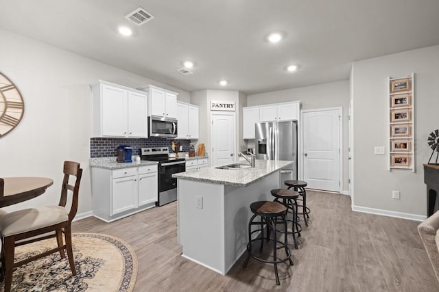 2046 Westbrook Rd, Commerce, GA 30530 - kitchen featuring appliances with stainless steel finishes, a sink, light wood finished floors, white cabinets, and recessed lighting