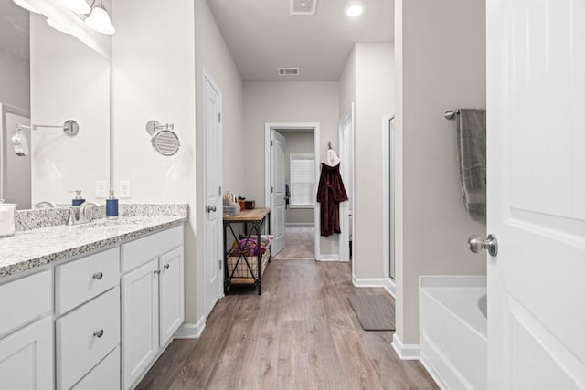 2046 Westbrook Rd, Commerce, GA 30530 - bathroom with wood finished floors, vanity, baseboards, a bath, and a shower with door