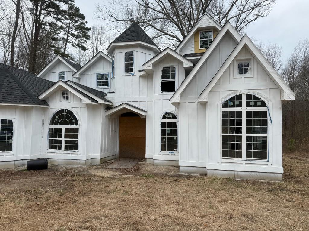 view of front facade featuring board and batten siding and a shingled roof