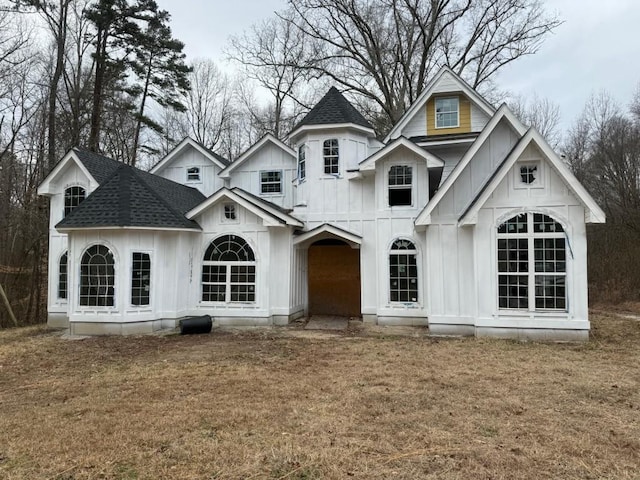 view of front of home featuring a shingled roof, board and batten siding, and a front yard