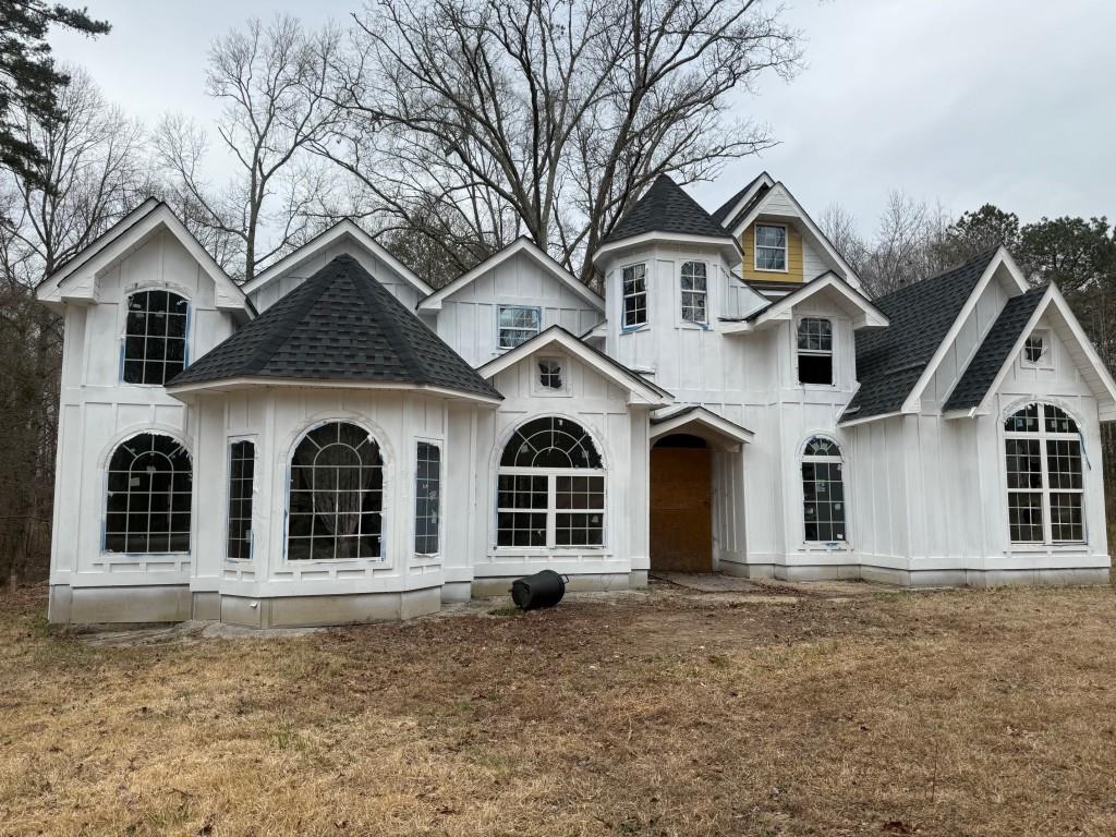 view of front of home featuring a shingled roof, board and batten siding, and a front yard