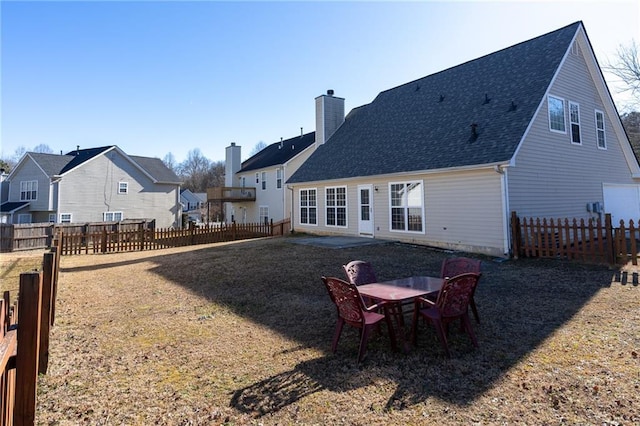 rear view of house featuring a yard