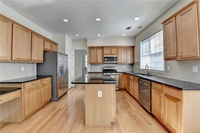 kitchen with stainless steel appliances, a center island, a sink, tasteful backsplash, and recessed lighting