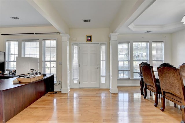 foyer entrance with ornate columns, light wood-style flooring, and baseboards