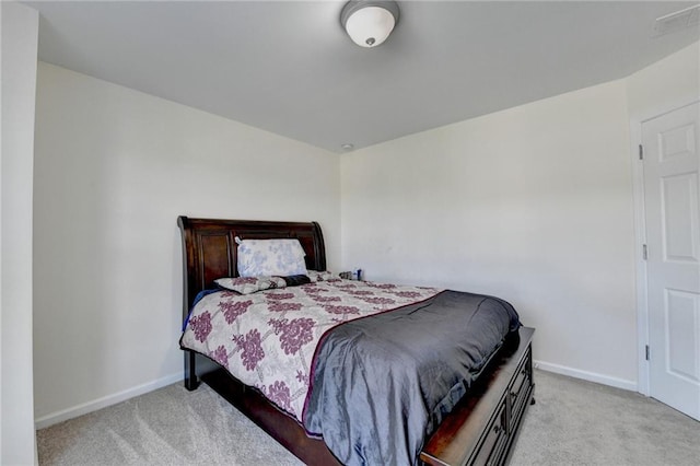 bedroom featuring light carpet and baseboards