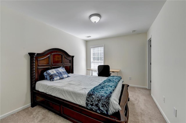bedroom with light colored carpet and baseboards