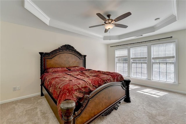 bedroom featuring a tray ceiling, crown molding, carpet flooring, baseboards, and ceiling fan