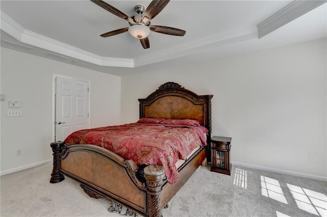 bedroom with a tray ceiling, carpet floors, crown molding, baseboards, and a ceiling fan