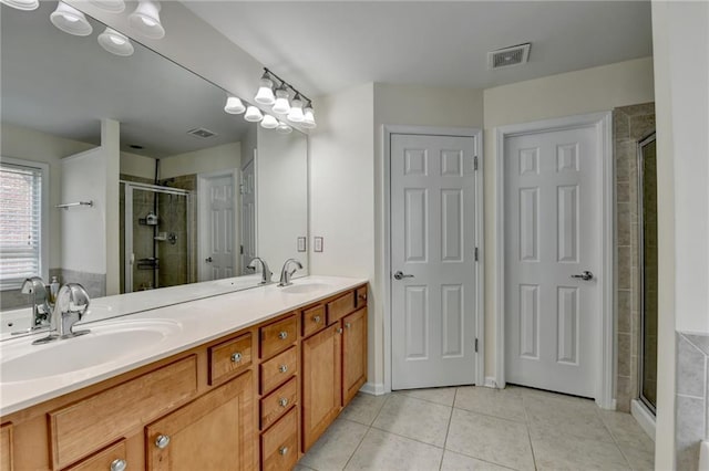 bathroom featuring a shower stall, tile patterned flooring, and double vanity