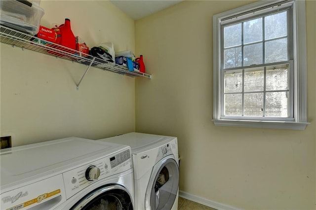 washroom with washing machine and clothes dryer, baseboards, and light tile patterned floors
