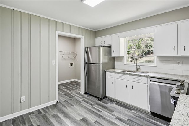 kitchen featuring stainless steel appliances, wood-type flooring, backsplash, sink, and white cabinetry