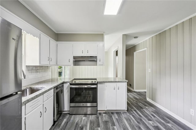 kitchen with light stone counters, white cabinets, stainless steel appliances, and dark wood-type flooring