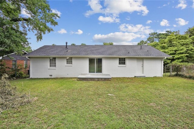 back of house featuring a lawn and a patio area