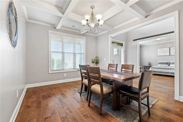 dining area featuring baseboards, wood finished floors, visible vents, and a chandelier