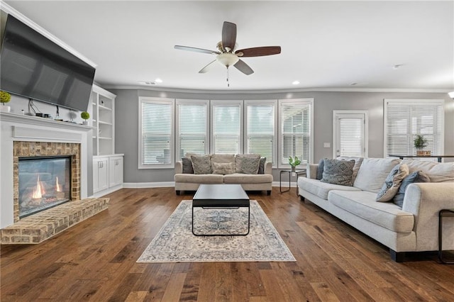 living room with crown molding, a fireplace, dark wood-style flooring, and baseboards