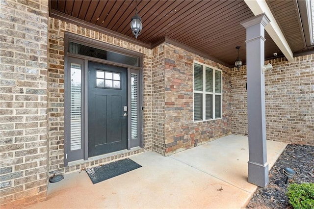 doorway to property with brick siding and a porch