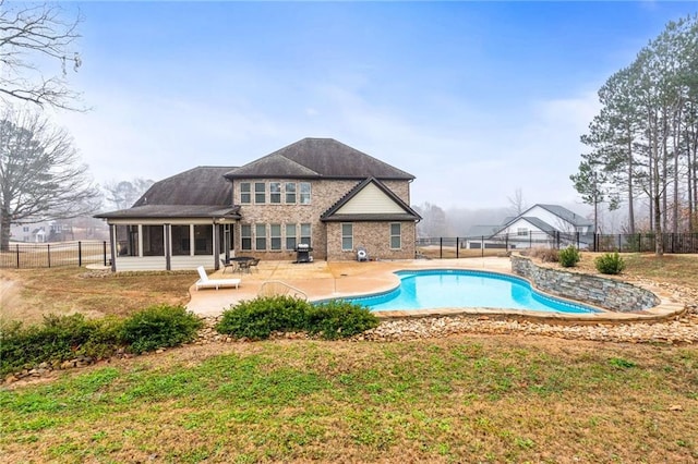 back of house featuring a fenced in pool, a patio, a fenced backyard, and a sunroom